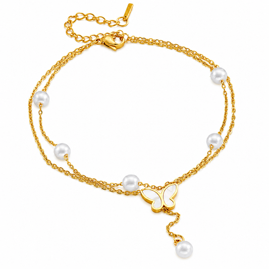 Gold anklet with pearls and a butterfly charm on a white background