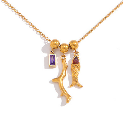 Gold necklace with three unique pendants on a white background