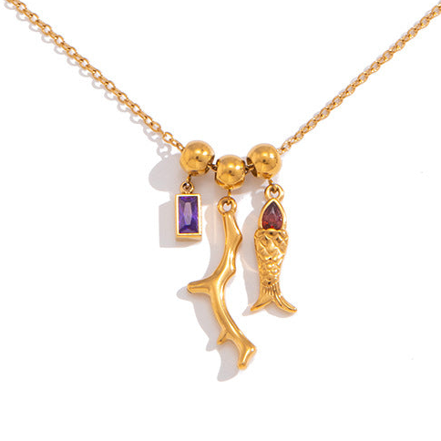 Gold necklace with three unique pendants on a white background