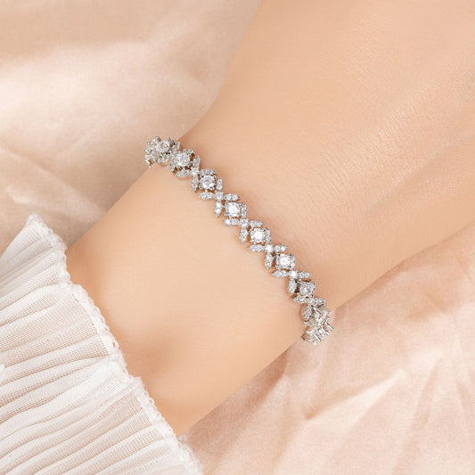 Silver bracelet with clear stones on a wrist against a soft beige background