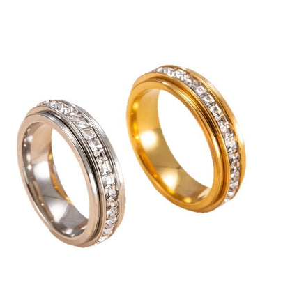 Two gold rings with diamond-studded bands on a white background