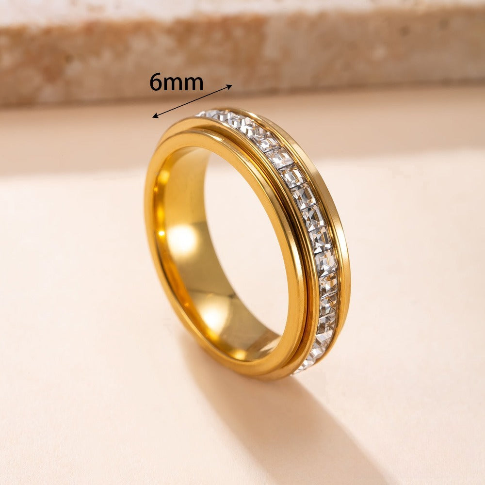 Gold ring with diamond accents on a beige background, showing a measurement of 6mm.