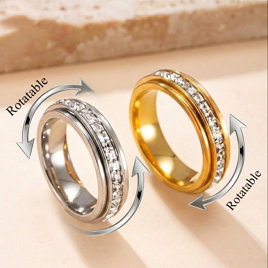 Two rotatable rings, one gold and one silver, on a beige background.
