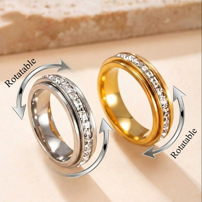 Two rotatable rings, one gold and one silver, on a beige background.