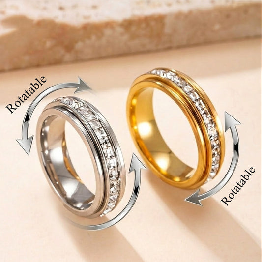 Two rotatable rings, one gold and one silver, on a beige background.