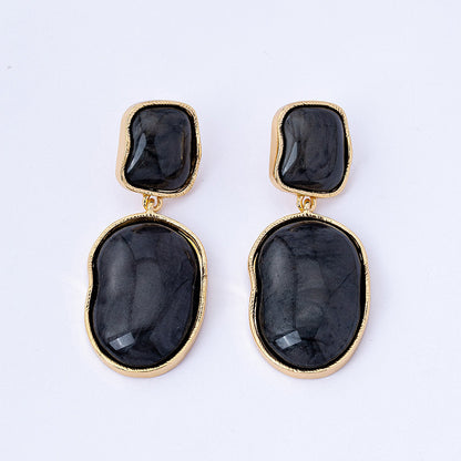 Pair of black stone earrings with gold accents on a white background