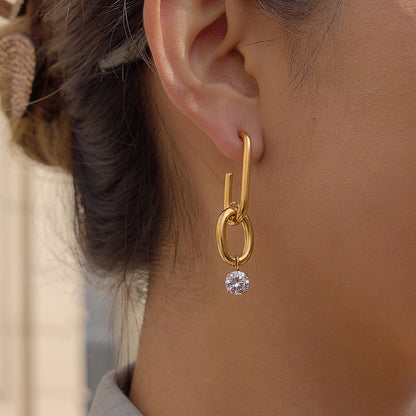 Gold earring with a diamond on an ear
