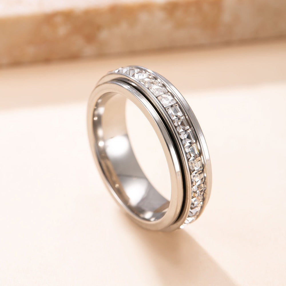 Silver ring with diamond accents on a beige background