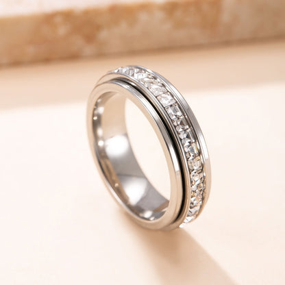 Silver ring with diamond accents on a beige background