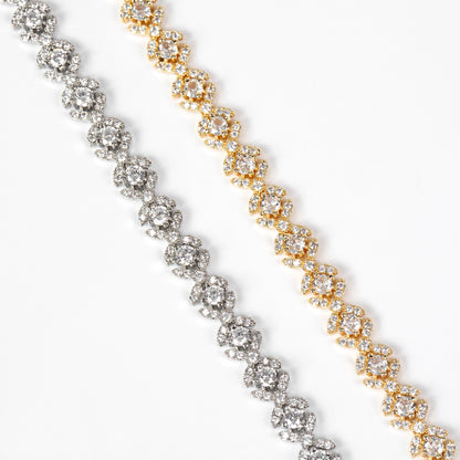 Two diamond tennis bracelets, one gold and one silver, on a white background.