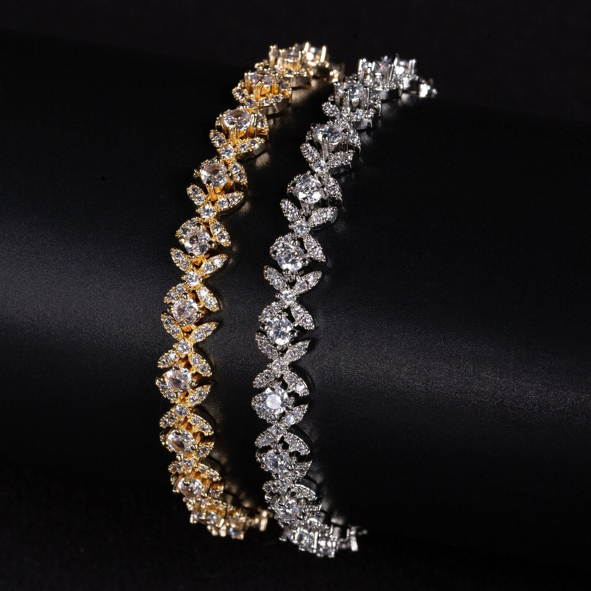 Two diamond bracelets, one gold and one silver, on a black background