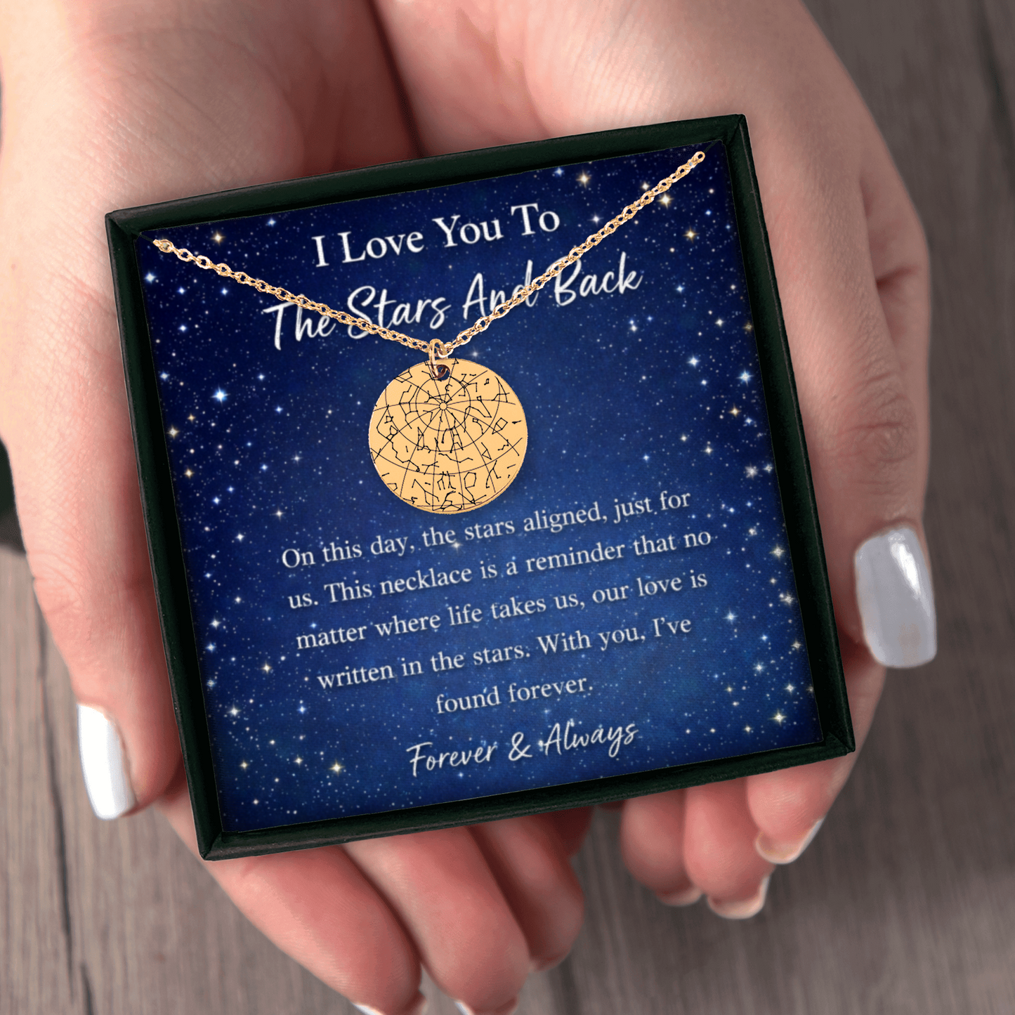 Gold necklace in a box with sentimental message held by a hand