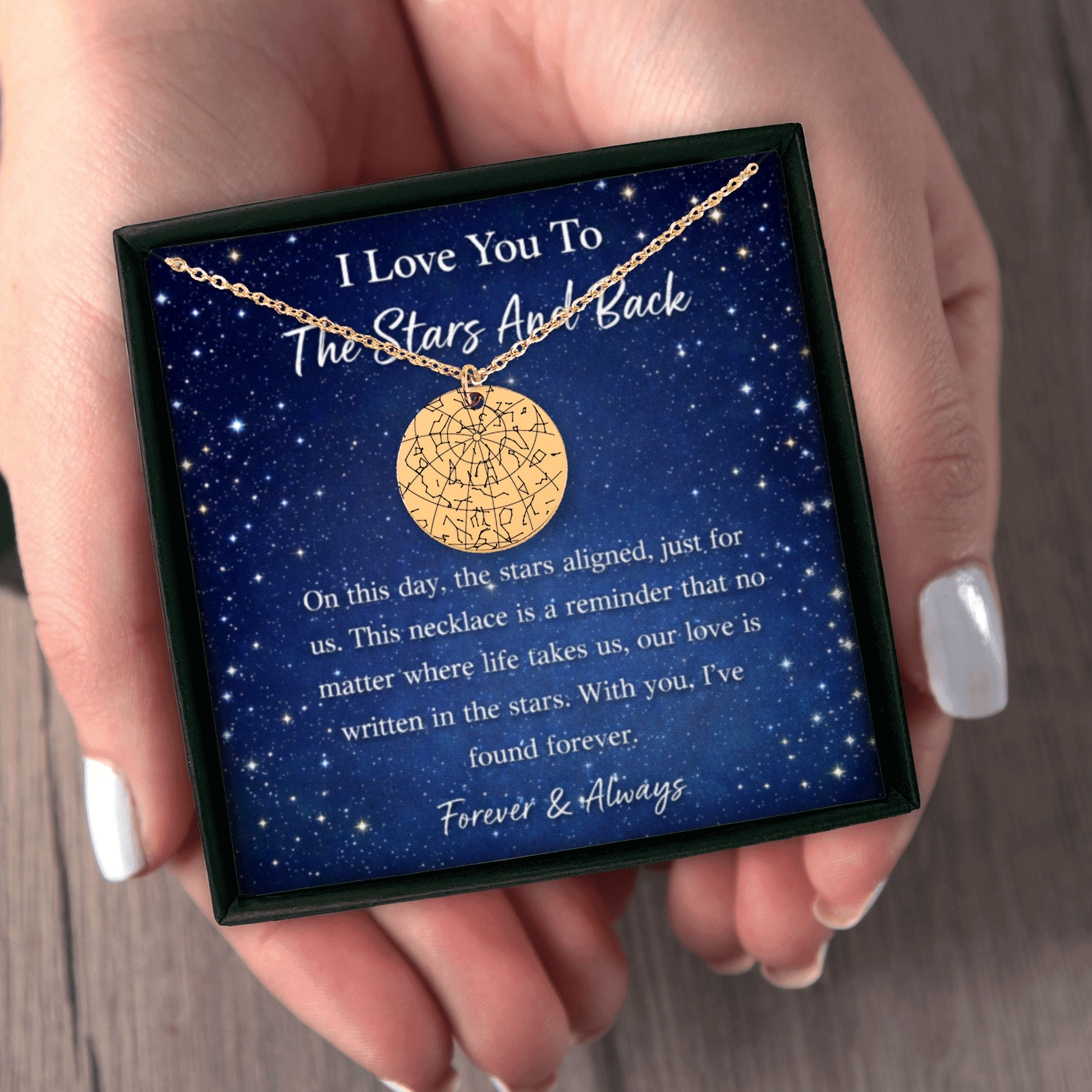 Gold necklace in a box with sentimental message held by a hand