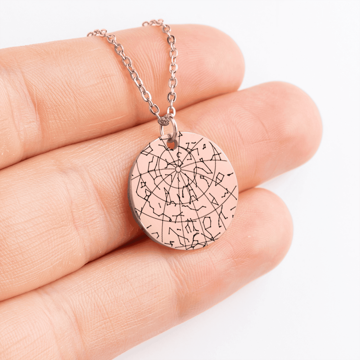 Necklace with a circular pendant held between fingers on a white background