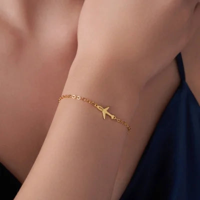 Gold bracelet with customized aeroplane charm on a person's wrist