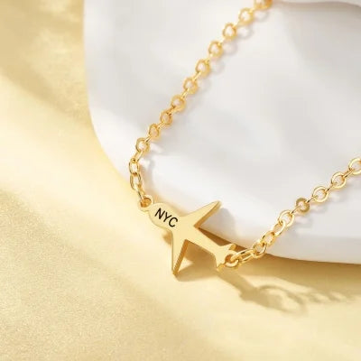 Gold necklace with a airplane-shaped pendant on a white background