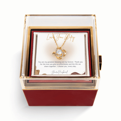 Jewelry box with a heart-shaped necklace and romantic message card on a white background