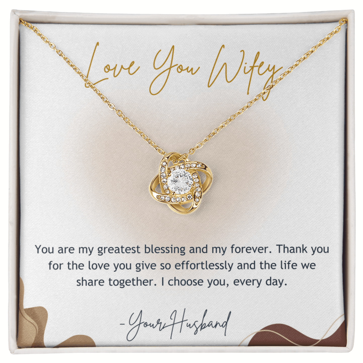 Gold necklace with heart-shaped pendant on a card that reads 'Love You Wifey'.