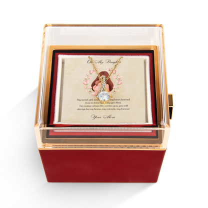 Gold necklace with a heart pendant in a decorative rotating rose box with a card inside.