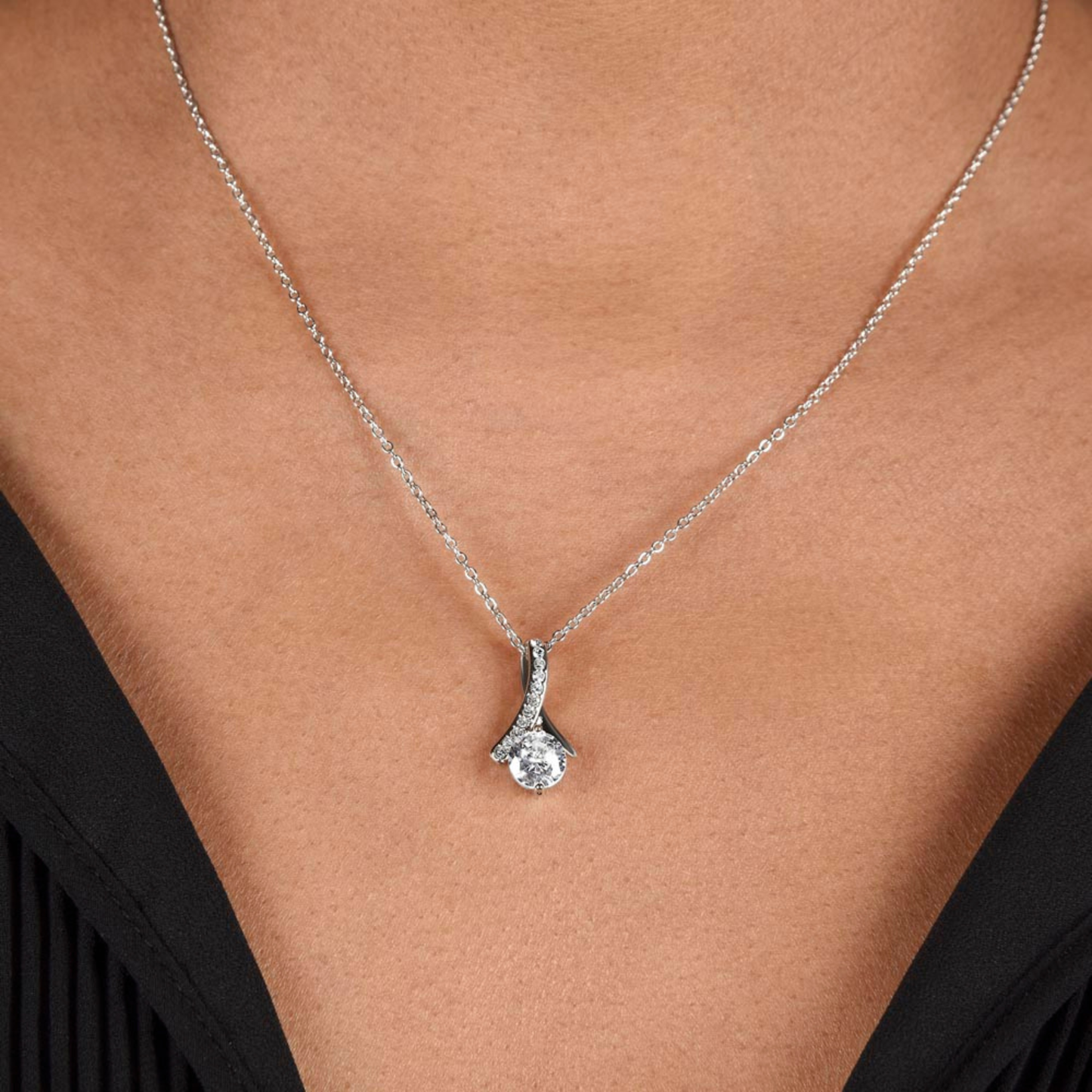 Alluring beauty Silver necklace with a pendant on a person wearing a black top