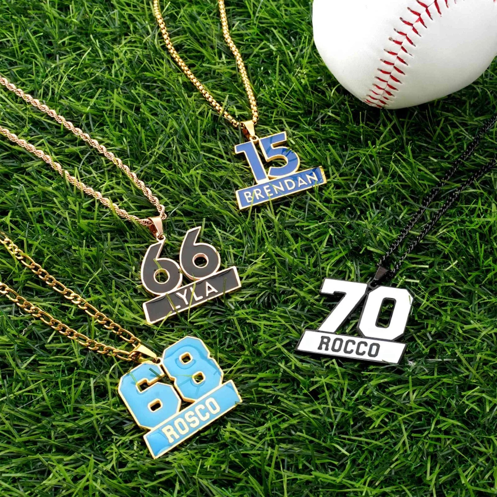 Four necklaces with numbers and names on grass next to a baseball