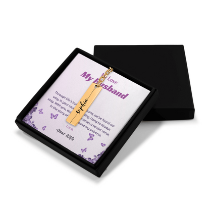 Gold necklace with a bar pendant on a card in a black box
