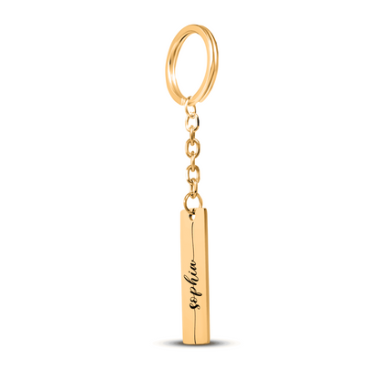Gold keychain with a cylindrical tag engraved with 'Sophia' on a white background