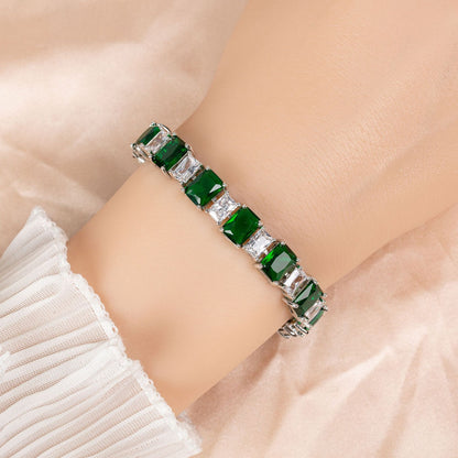 Green gemstone bracelet on a person's wrist with a soft background