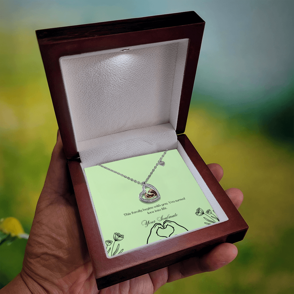 Baby feet necklace in a wooden box with LED in a blurry background