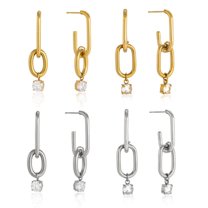 Set of gold and silver earrings with clear gemstones on a white background