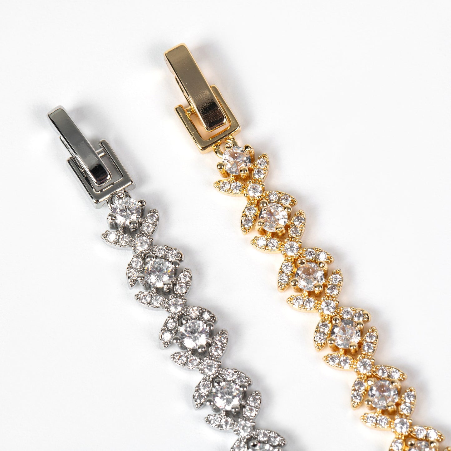 Gold and silver bracelet with floral design on a white background