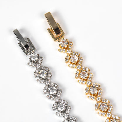 Gold and silver bracelet with floral design on a white background
