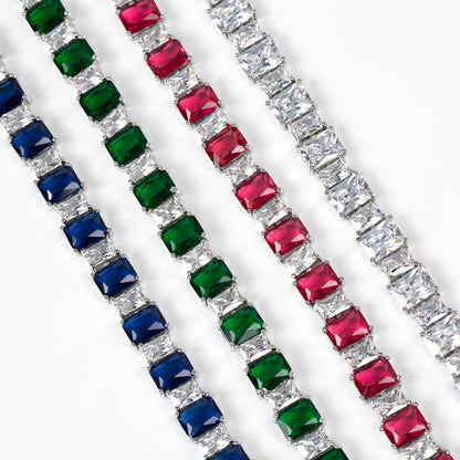 Three diamond bracelets with colored gemstones on a white background