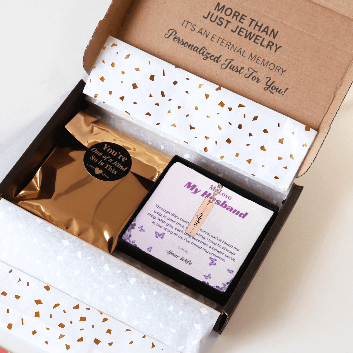 Jewelry box with a personalized card and jewelry inside, on a white background.