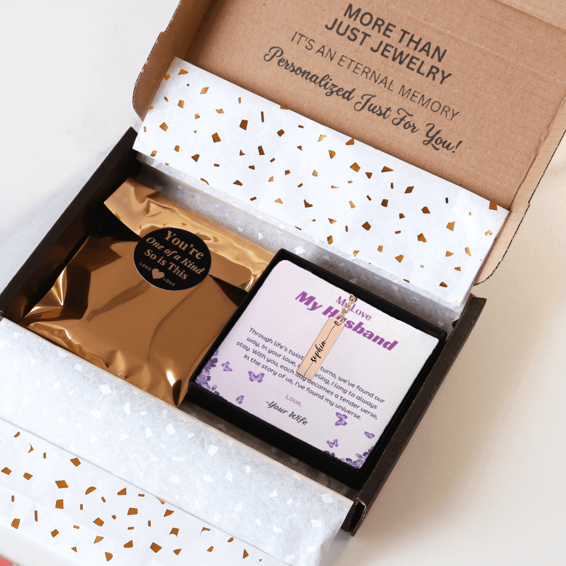Jewelry box with a personalized card and jewelry inside, on a white background.