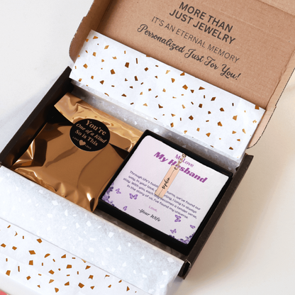 Jewelry box with a personalized card and jewelry inside, on a white background.