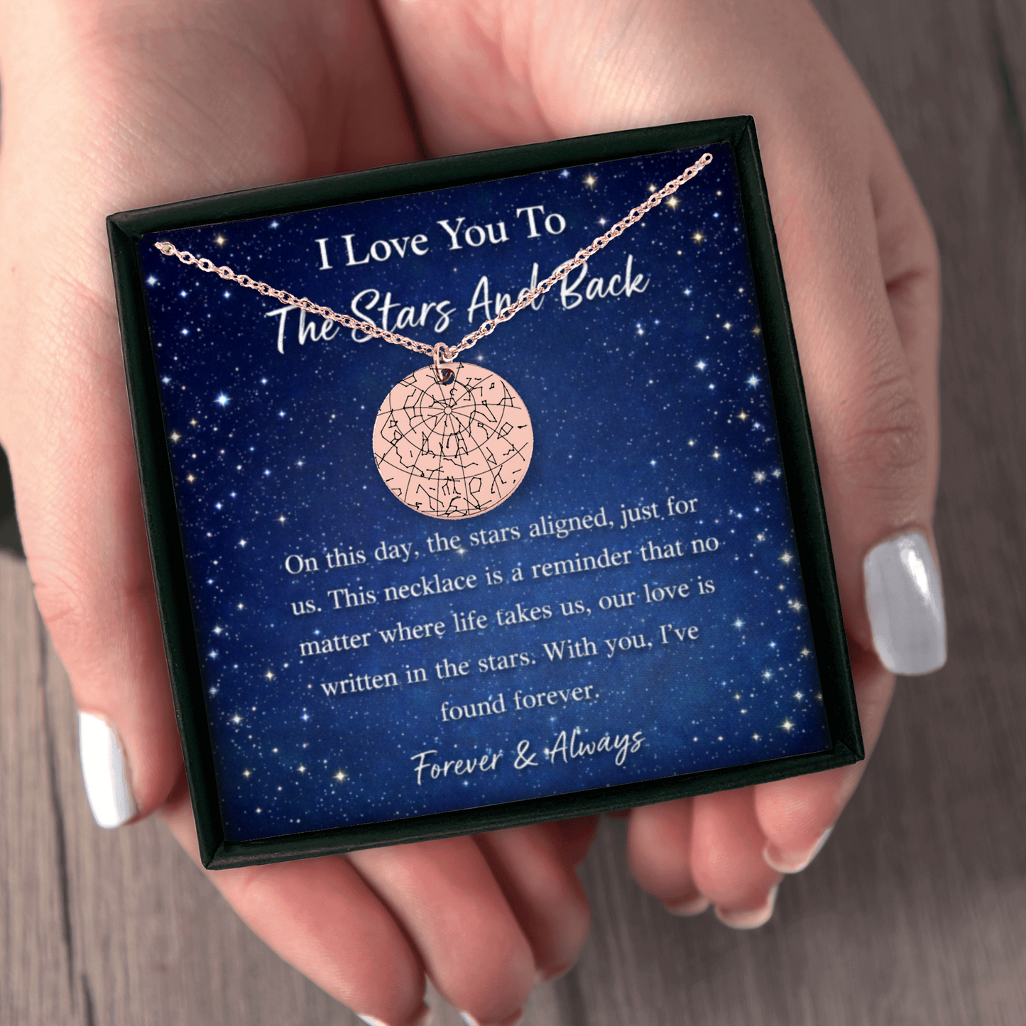 Necklace with star design in a box with sentimental message, held by a hand.